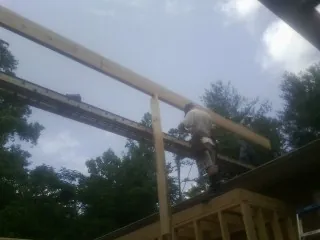 Carpenter setting a ridge beam over a new addition frame — Ice Dam Removal by Roofing Brothers in Far Hills