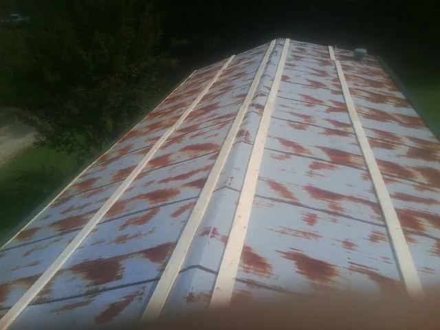 Rusted metal roof panels with new wood purlins before replacement — Storm Damage Roof Repair in Far Hills by Roofing Brothers