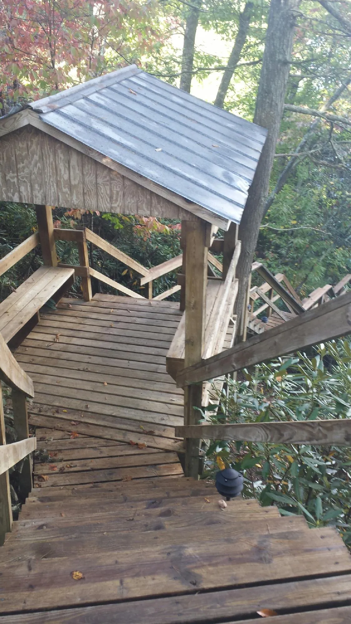 Metal roofed shelter over wooden steps on a wooded walkway — Skylight Repair & Installation work by our crew in Far Hills
